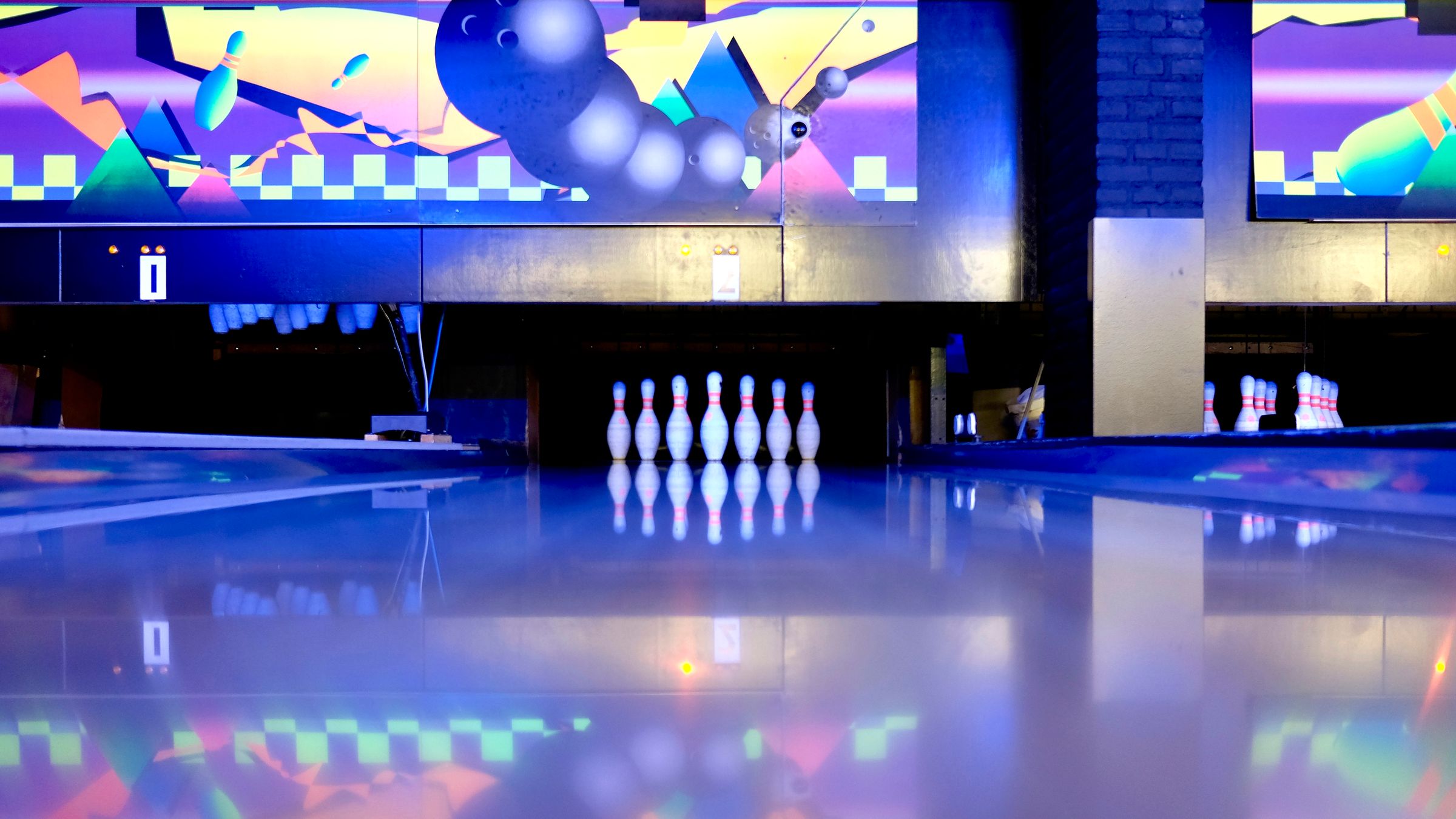 Venue interior with dining seating beneath sports screens